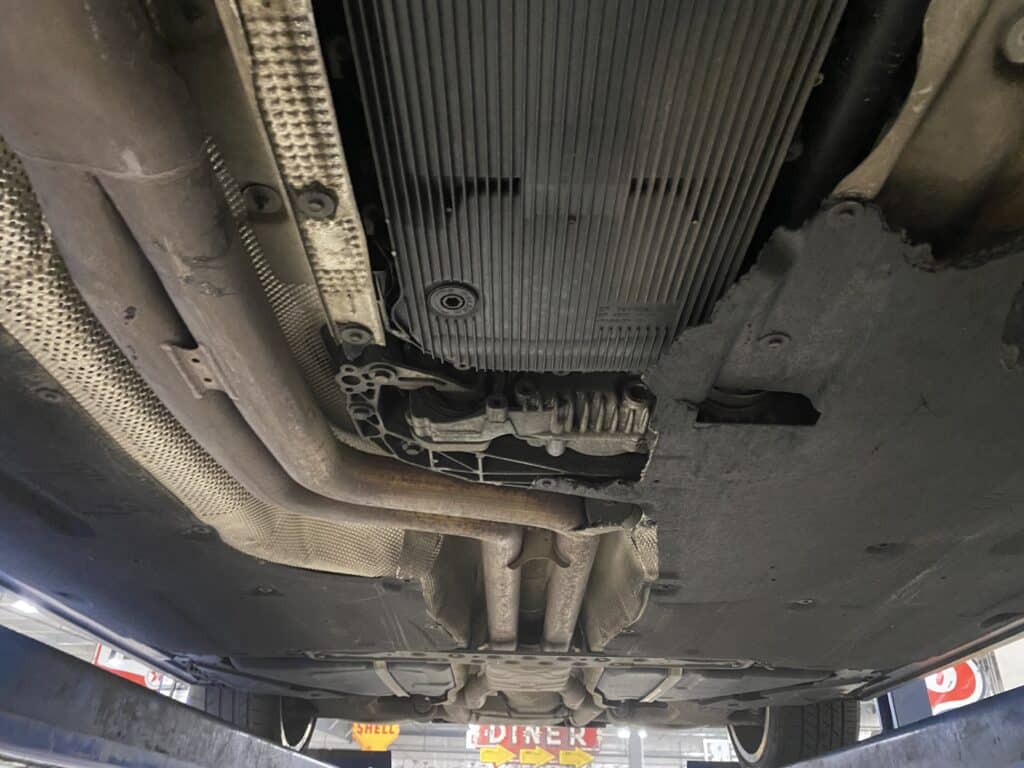 Soaked undercarriage cover found during pre-purchase used car inspection