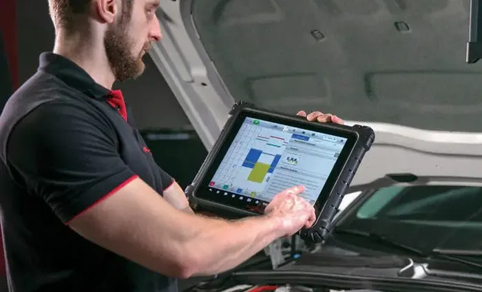 A technician conducts a vehicle diagnostic scan to evaluate car health